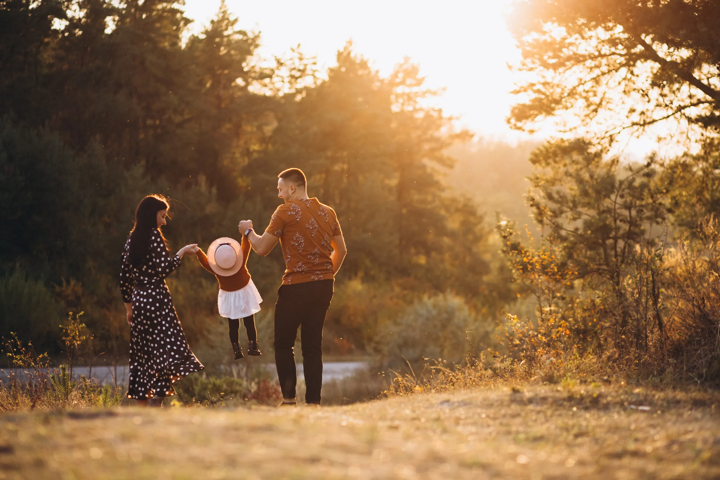 Una familia camina al atardecer con su hija de la mano