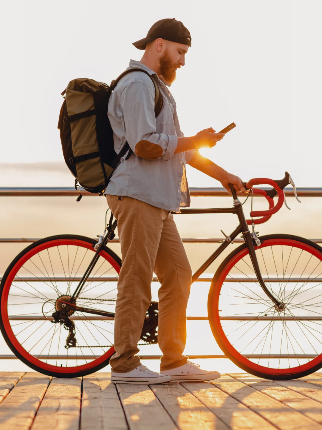 Un hombre con su bicicleta junto al mar al amanecer