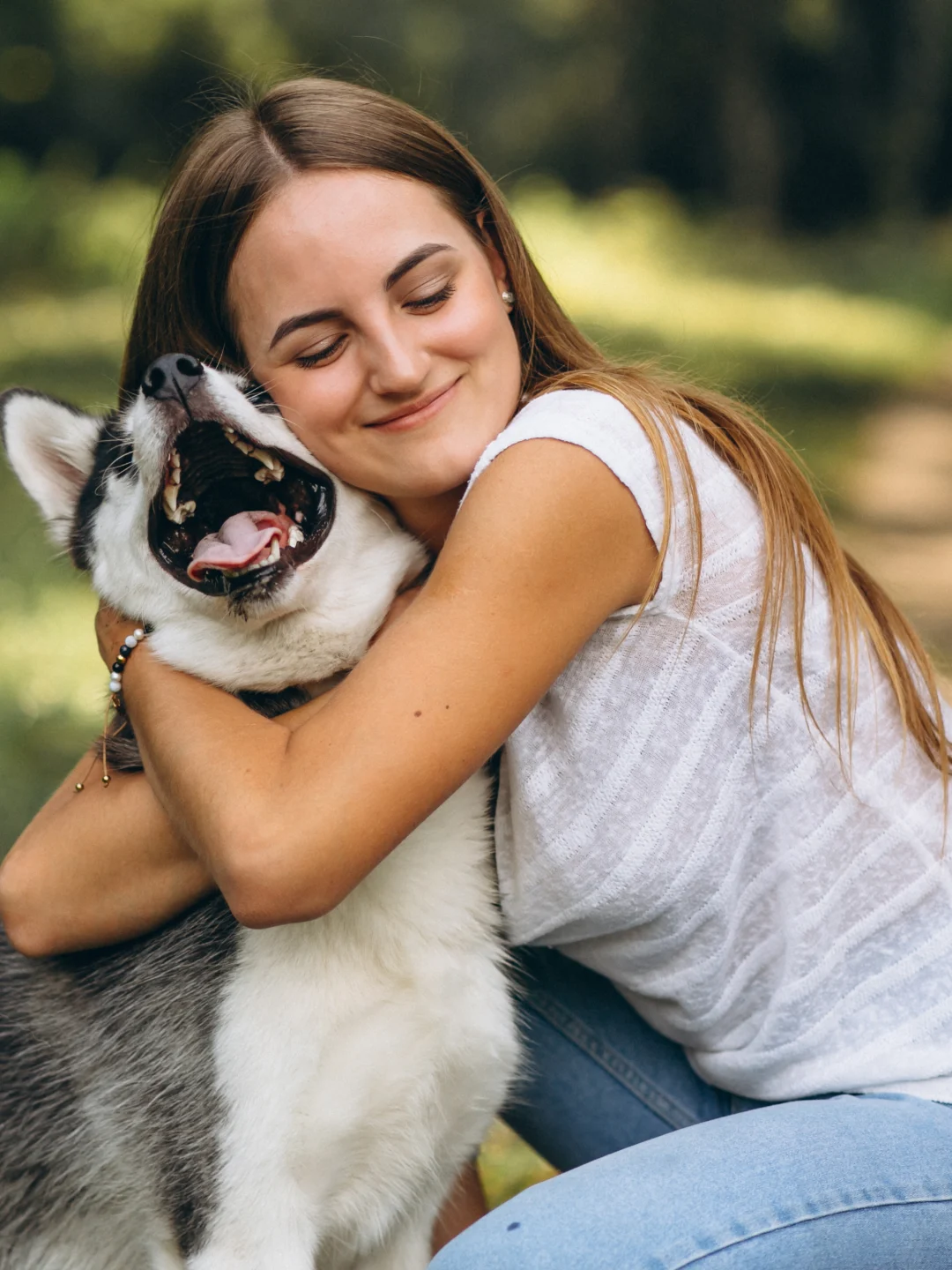 Una joven abraza a su perro en el parque